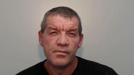 Mugshot of Keith Bretherton,. He has short grey hair, a five o'clock shadow and is wearing a black t-shirt.