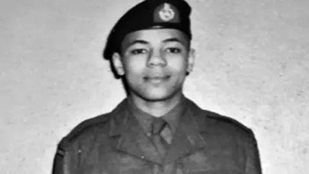 A young man looking proud in his Royal Marine uniform and beret in a black and white picture