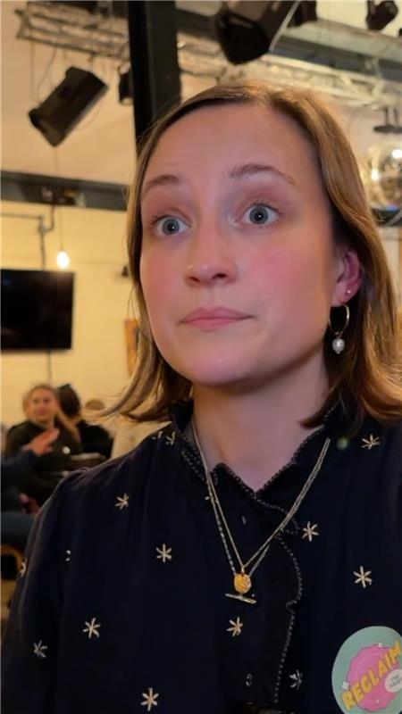 A woman in a black top with blonde hair.