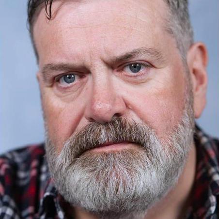 A man with a greying beard and a check shirt