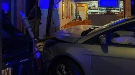 Two vehicles outside the front of the restaurant