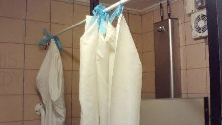 A picture of some broken shower curtains in a prison 