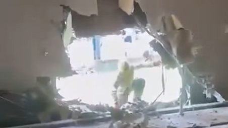 A fire man in a large hole in a wall