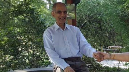 Bhim Kohli is pictured smiling at the camera, wearing a powder-blue shirt
