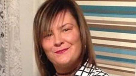 A close up of Frances Dwyer wearing pink lipstick hoop earrings and a black and white shirt