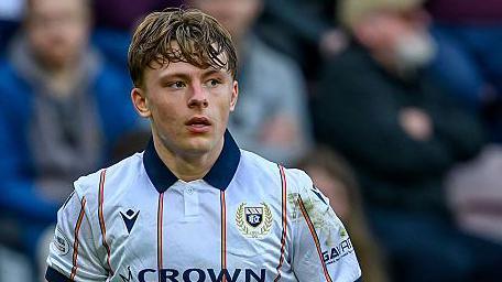 Luke Graham in action for Dundee. He is wearing a white shirt with thin organe stripes with a navy blue collar.