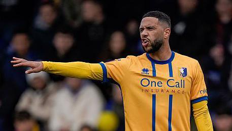 Tyler Roberts points out instructions to team-mates during a game for Mansfield