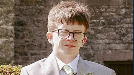 A man in glasses wearing a suit
