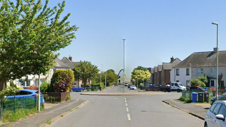 A street with a large roundabout in the middle and houses on either side