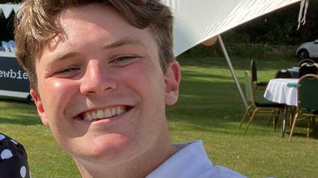 Charlie Saywell smiling and wearing a white polo shirt