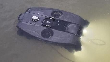 A small black water-based vehicle floats on water