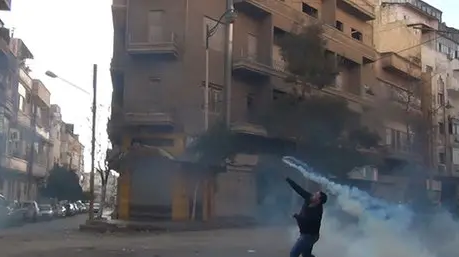 A protestor in front of a block of flats