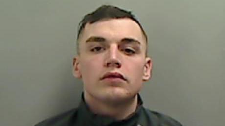 Mugshot of McElvaney. He is clean shaven with short dark hair.