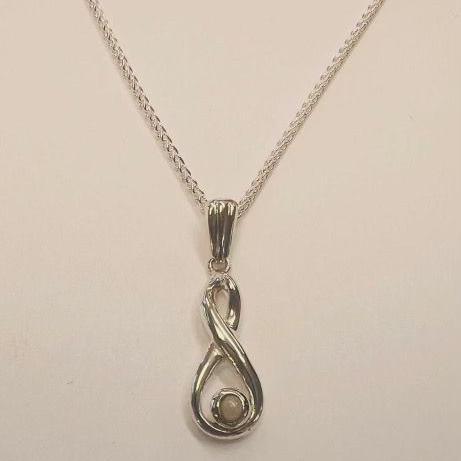 A silver necklace on a cream background. The necklace has a pendant shaped like a figure of eight, with a larger lower loop and a small pearl resting in the lower loop.