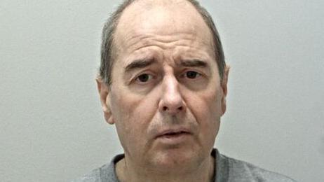 Mugshot of Alan Murphy with balding hair and a grey sweater 