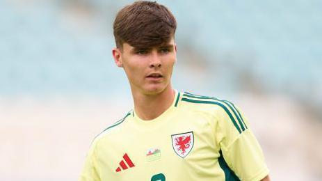 Charlie Crew while playing for Wales in a yellow change strip