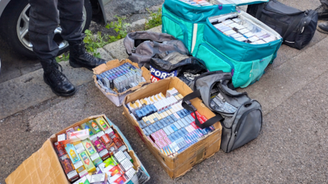 Several large boxes on the ground packed with cigarettes and vapes