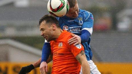 Glenavon striker Declan O'Brien is beaten to the high ball by Andrew Burns