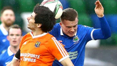 Armagh City's Conor McAnallen and Linfield midfielder Aaron Burns battle for the high ball