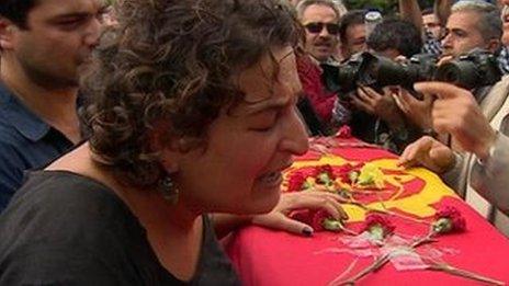 Mourners around a coffin