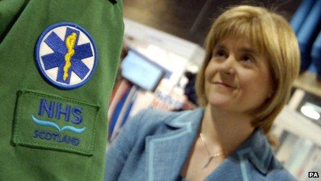 Nicola Sturgeon looking talking to someone from the NHS in Scotland