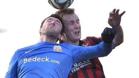 Glenavon's Gareth McKeown and Crusaders striker Jordan Owens contest a high ball