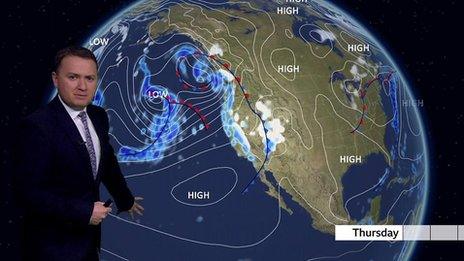 Matt Taylor stands in front of a weather map of the US