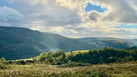 The sun breaking through clouds over Pontypridd in Wales