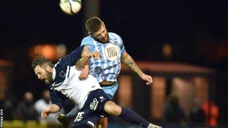 Ballinamallard's Ivan Sproule is beaten to the high ball by Warrenpoint opponent Mark Clarke