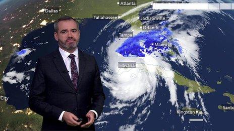 Ben Rich stands in front of a weather chart showing Hurricane Ian's track