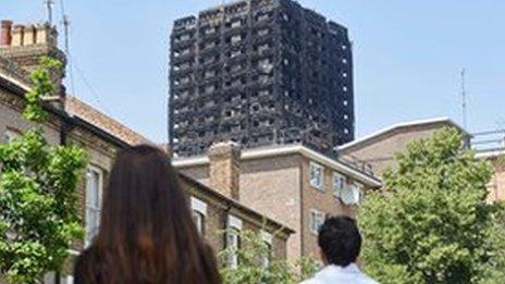 people looking at burnt out grenfell tower