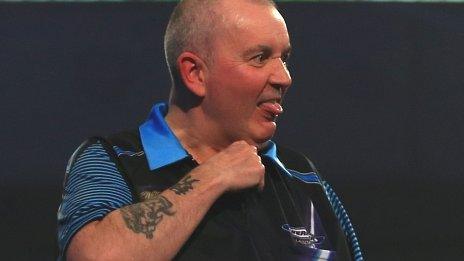 Phil Taylor makes a throat-cutting gesture after narrowly avoiding losing a set