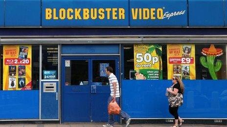 People walk past Blockbusters store