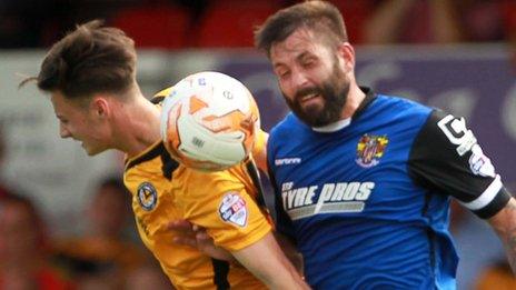 Aaron Collins of Newport County and Dean Wells of Stevenage challenge for the ball