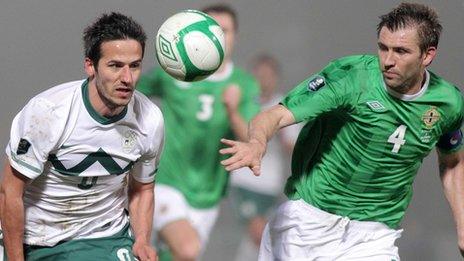 Slovenia's Zlatan Ljubijankic is challenged by Gareth McAuley in the Euro 2012 qualifier in Belfast