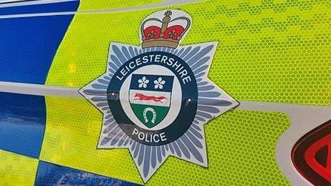 Close up of the Leicestershire Police badge on the side of a police car