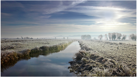 Frosty fields with partly cloudy skies above