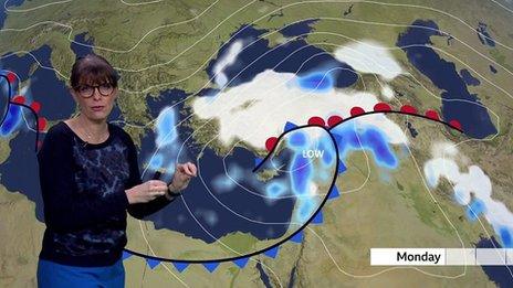 Susan Powell stands in front of a weather map of Turkey