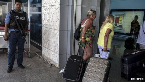 A policeman stands guard while tourists leave at the Enfidha international airport in Sousse, Tunisia