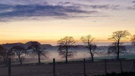 Mist lingers between trees in Philpstoun, West Lothian, with yellow skies above