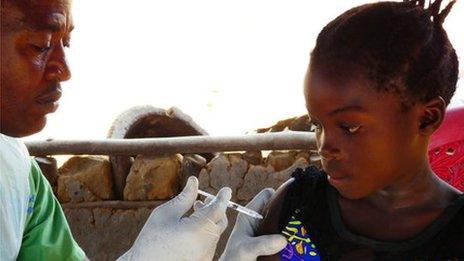 Ugandan girl being given HPV vaccine funded by UK aid.