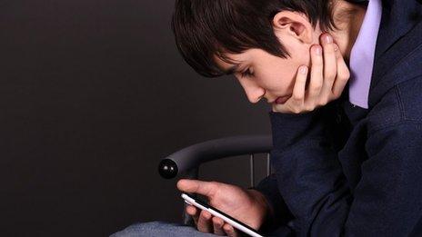 boy looking down at phone