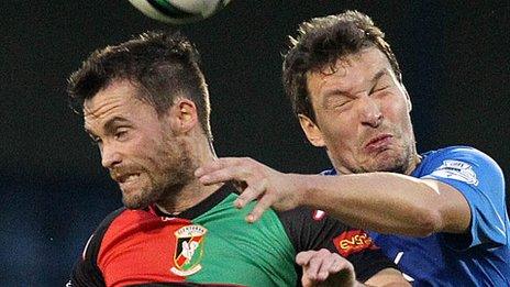 Glentoran's David Scullion competes against Kyle Neill of Glenavon