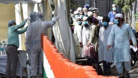 People who took part in a Tablighi Jamaat function earlier this month are checked by a health team before being taken by bus to a quarantine facility amid concerns of infection.