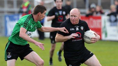 Castlewellan's Barry Travers challenges Kilcoo opponent Anthony Devlin