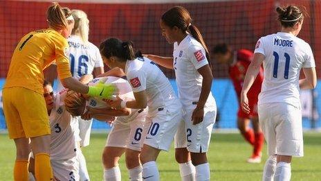 Laura Bassett of England is comforted by team-mates