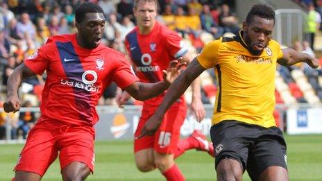 Lenell John Lewis of Newport County shields the ball from Marvin McCoy