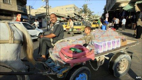 A Palestinian vendor rides on horse-cart in central Gaza City, 17 June