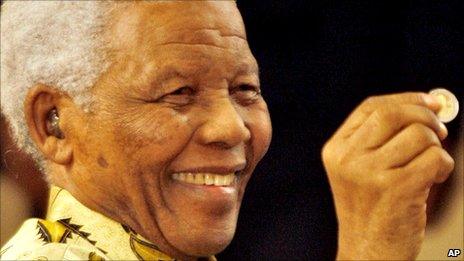 Nelson Mandela holding up a newly minted presidential coin in September 2009