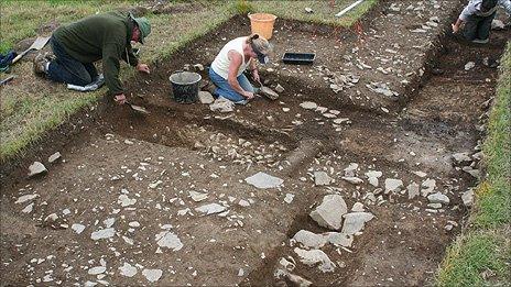 Archaeologists dig showing the excavated walls of the villa